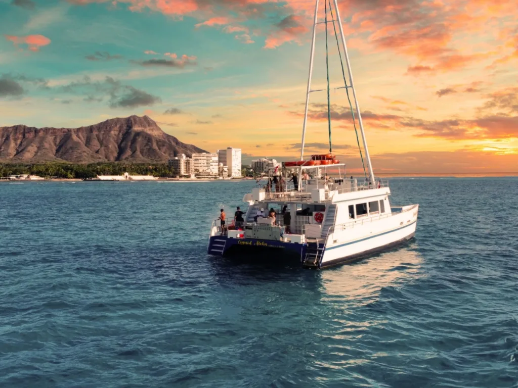 Boat cruising along Waikiki coast during a vibrant sunset tour