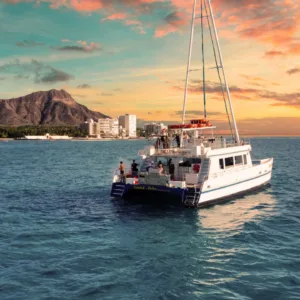 Boat cruising along Waikiki coast during a vibrant sunset tour