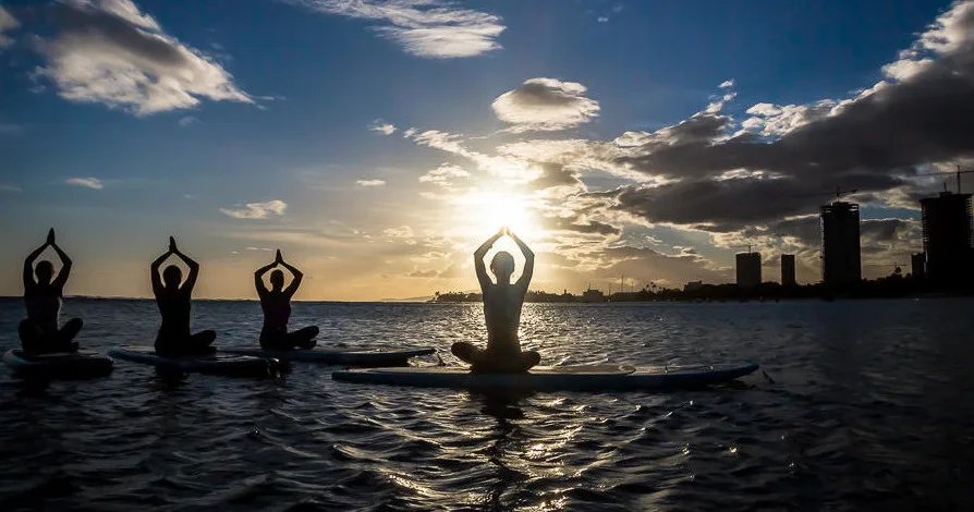 Practice yoga on a stand-up paddleboard in calm waters