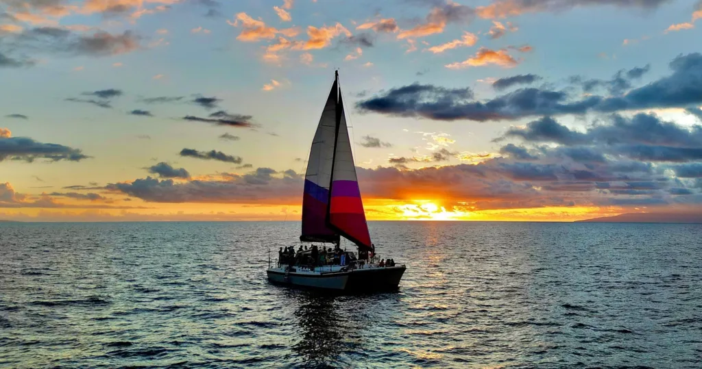 Sunset sailing on a tiki bar catamaran with guests relaxing