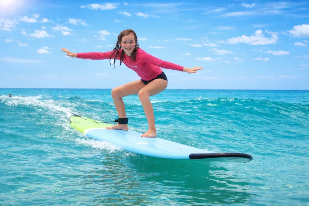 Family learning to surf together on gentle island waves