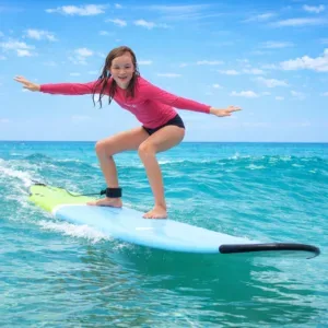 Family learning to surf together on gentle island waves