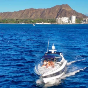 Cruise boat sailing under city lights at sunset on the water