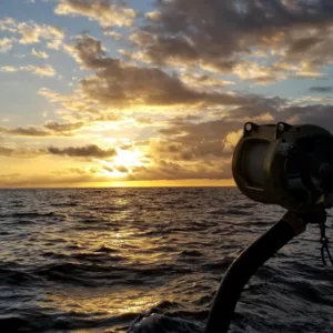 Fishing boat cruising at sunset on the ocean