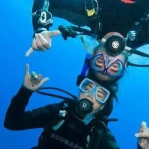 Instructor guiding scuba diving beginners underwater
