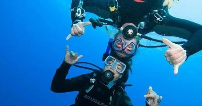 Instructor guiding scuba diving beginners underwater