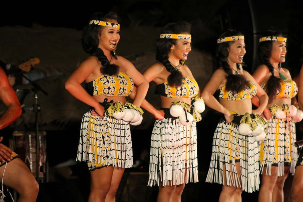 Guests enjoying traditional Hawaiian luau under evening sky