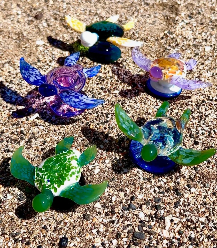 Artist shaping molten glass in flameworking studio workshop