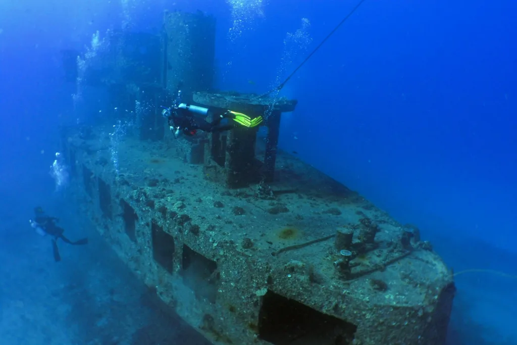 Scuba divers exploring shipwreck underwater near Waikiki