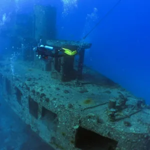 Scuba divers exploring shipwreck underwater near Waikiki