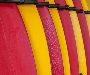 Customer selecting a surfboard at the rental shop