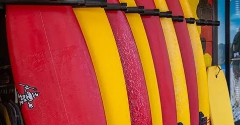 Customer selecting a surfboard at the rental shop