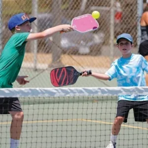 Kids practicing pickleball skills on outdoor court