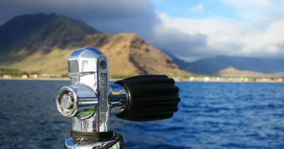 Divers exploring underwater lava tube on Oahu dive