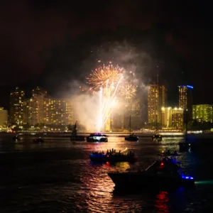 Private boat cruising under colorful sunset skies with fireworks