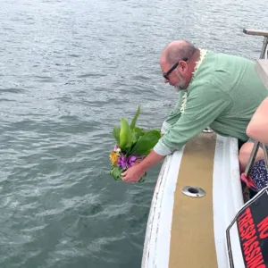 Ceremonial burial at sea with ocean backdrop