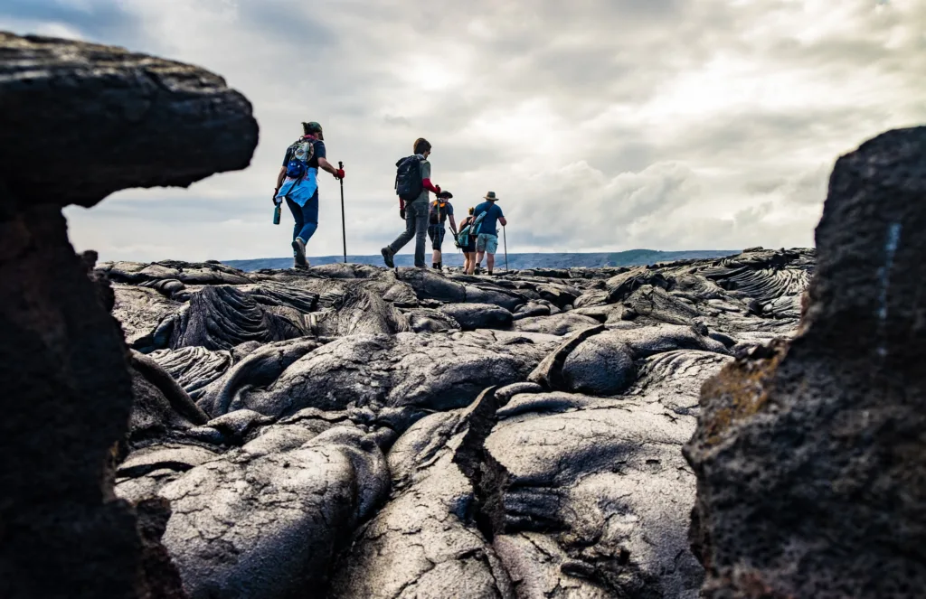 Hiker trekking volcanic terrain with steam vents nearby