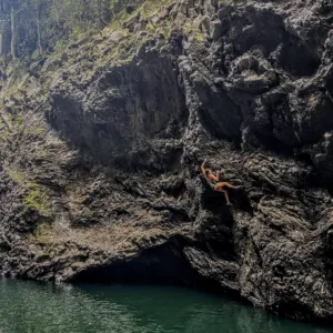 Climber scaling a rock face on Big Island
