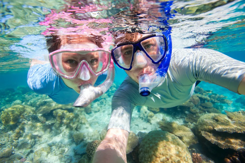 Tourists snorkeling in clear waters near Honolulu shore