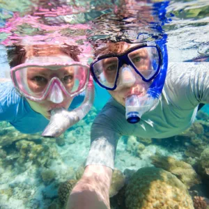 Tourists snorkeling in clear waters near Honolulu shore