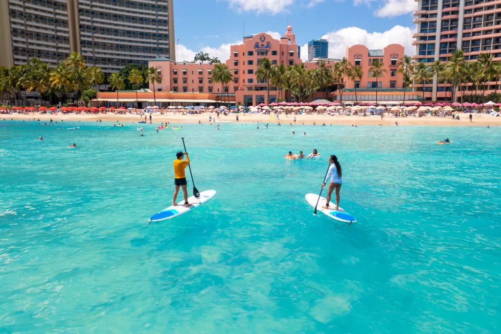 Individual receiving one-on-one stand-up paddleboarding lesson