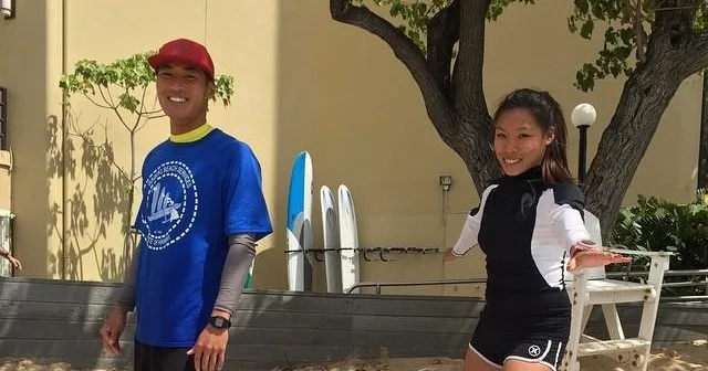 Valet assisting guests with water activity equipment on beach