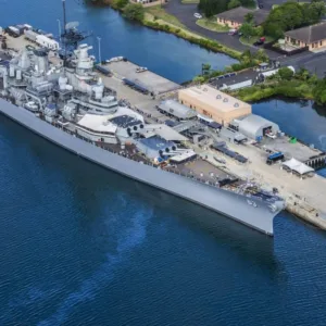 Battleship Missouri docked at Pearl Harbor with helicopter overhead