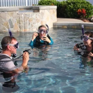 Scuba diving students practicing skills in a clear pool