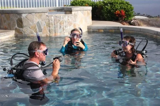 Scuba diving students practicing skills in a clear pool