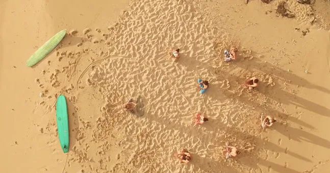 Participants practicing yoga after surfing on Kauai’s beaches