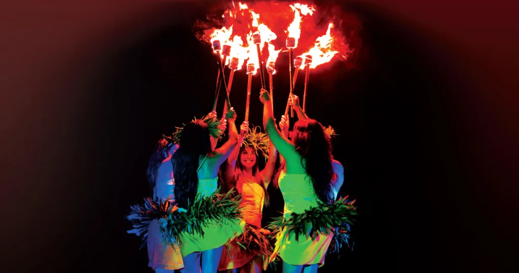 Performer spinning fire sticks during Ahi Lele show Kauai