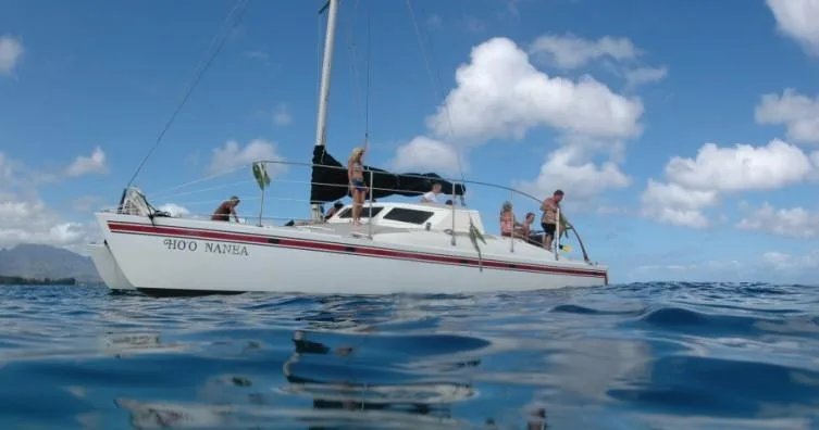 Sailboat cruising with snorkelers ready for morning adventure