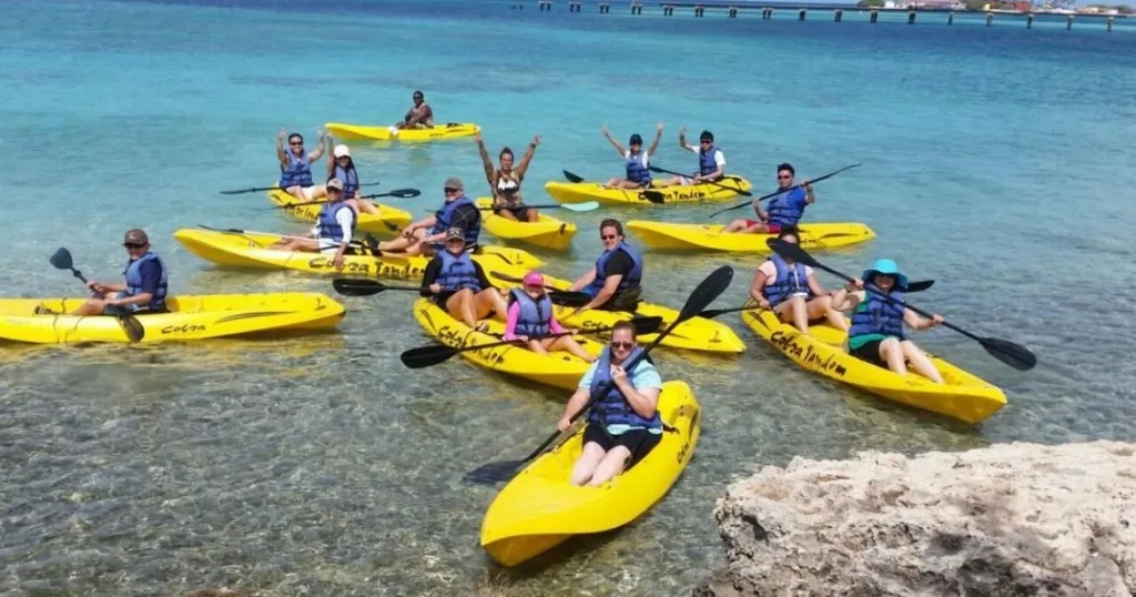 Kayakers paddling through calm waters near coral reefs
