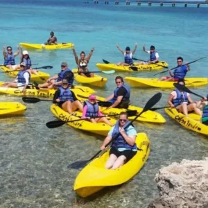 Kayakers paddling through calm waters near coral reefs