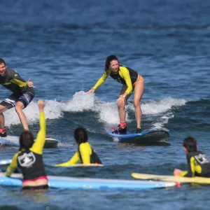 Group of surfers learning to ride waves together