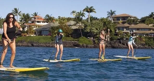 Stand up paddleboarder gliding across calm Hawaiian waters