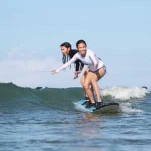 Private surf lesson with instructor guiding student on Maui beach