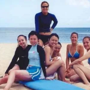 Group of surfers catching waves during lesson at sunset