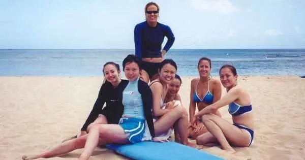 Group of surfers catching waves during lesson at sunset