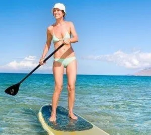 Instructor guiding private paddle boarding lesson on calm water