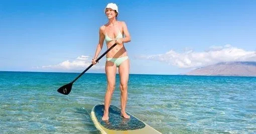 Instructor guiding private paddle boarding lesson on calm water