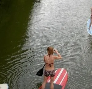 Two participants learning paddle boarding in semi private lesson