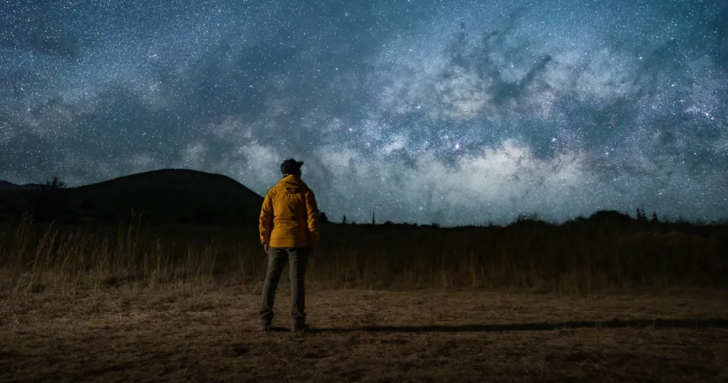 Stargazers observing Mauna Kea night sky with telescope