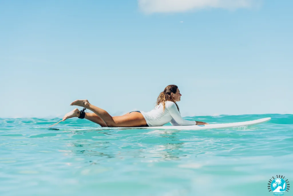 Adult receiving private surf lesson on calm beach waves