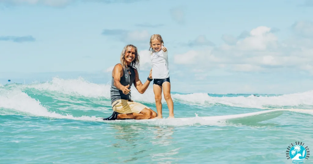 Instructor guiding two kids during private surf lesson