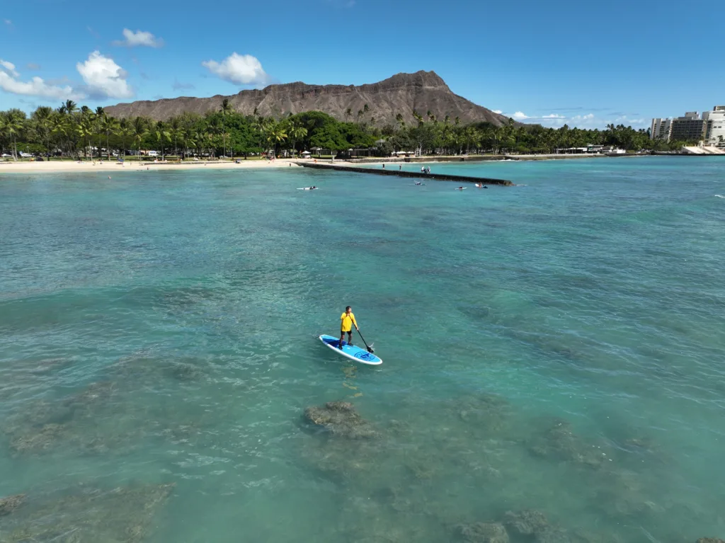 Paddleboarder learning balance on calm ocean waters