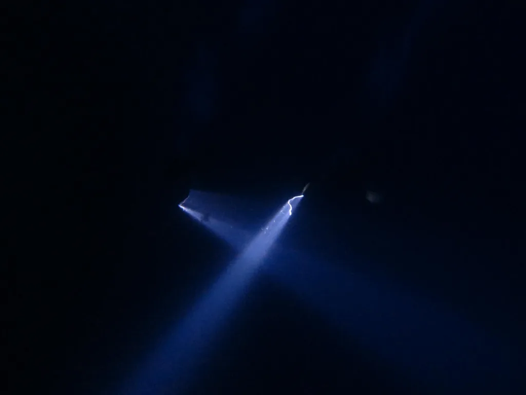 Night scuba diver exploring deep ocean pelagic zone