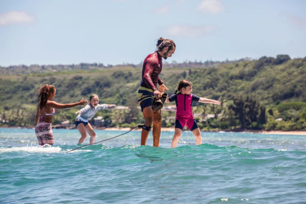 Child and instructor tandem surfing lesson