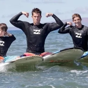 Group of beginner surfers learning to surf in ocean