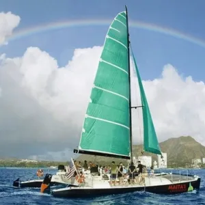 Sailboat cruising Waikiki with passengers enjoying drinks
